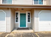 Thumbnail 11 of 48 - A house with a blue door and white garage doors.
