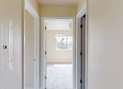 Thumbnail 35 of 48 - A white door is open to a hallway.