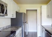 Thumbnail 41 of 48 - A kitchen with white cabinets and granite countertops.