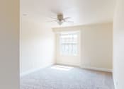 Thumbnail 47 of 48 - A room with a ceiling fan and a window letting in sunlight.