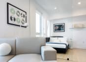 Thumbnail 7 of 24 - a living room with a couch and a table with two wine glasses