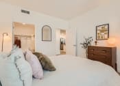 Thumbnail 54 of 69 - a bedroom with a large bed and a dresser with a mirror