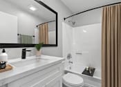 Thumbnail 18 of 30 - Beautiful updated bathroom in 1 Bed 1 Bath Azusa Gardens Apartment home with white shaker cabinets, quartz countertops, matte black finishes, and a large shower/tub