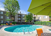 Thumbnail 9 of 37 - Resort-style swimming pool at Caifornia Place in gated pool area surrounded by lush greenery and blue skies for a beautiful and relaxing poolside experience