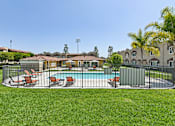 Thumbnail 8 of 30 - View of Azusa Gardens Pool Area inclosed by an iron fence for safety. Pool area is surrounded by lush greenery.