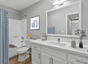 Thumbnail 27 of 30 - Spacious bathroom in 2 Bed 1 Bath Azusa Gardens Apartment home with wood-style plank flooring, large vanity, white shaker cabinets, quartz countertops, brushed nickel finishes, and a large shower/tub