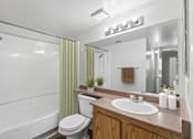 Thumbnail 31 of 37 - Bathroom in 1 Bed 1 Bath B California Place apartment home with light wood cabinets, a large vanity mirror, and shower/tub
