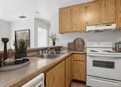 Thumbnail 35 of 37 - Kitchen in 1 Bed 1 Bath A California Place floor plan with light wood cabinets, white appliances, plenty of counter and storage space for all of your needs, and wood-style plank flooring