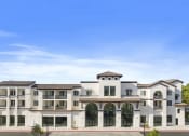 Thumbnail 26 of 69 - a large apartment building with a blue sky in the background at The Venue at Orange Apartments, Redlands, California