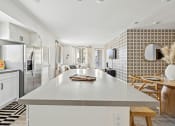 Thumbnail 42 of 69 - a kitchen with a white counter top and a stainless steel refrigerator