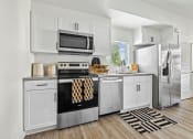 Thumbnail 48 of 69 - a kitchen with stainless steel appliances and white cabinetry