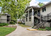 Thumbnail 10 of 31 - Charming exterior of Bent Tree Apartments with grass lined walkways, large trees, and quaint architectural details giving Bent Tree a homey and cozy feel like no other!