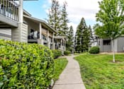Thumbnail 9 of 31 - Charming exterior of Bent Tree Apartments with grass lined walkways, large trees, and quaint architectural details giving Bent Tree a homey and cozy feel like no other!