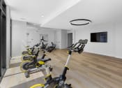 Thumbnail 17 of 69 - a gym with rows of exercise bikes and a tv on the wall at The Venue at Orange Apartments, Redlands, 92373