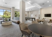 Thumbnail 9 of 69 - a clubhouse with couches tables and chairs and a television at The Venue at Orange Apartments, Redlands, California