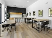 Thumbnail 11 of 69 - a dining room with tables and chairs and a kitchen at The Venue at Orange Apartments, California, 92373