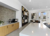 Thumbnail 7 of 69 - a kitchen and living room with a white counter top at The Venue at Orange Apartments, Redlands, CA, 92373