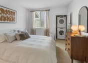 Thumbnail 55 of 69 - a bedroom with a bed and a washer and dryer