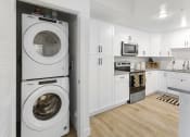 Thumbnail 50 of 69 - a white kitchen with a washing machine and a washer and dryer in it