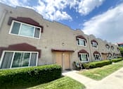 Thumbnail 11 of 30 - Azusa Gardens Apartment exterior surrounded by grass-lined walkways