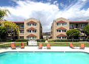 Thumbnail 4 of 30 - Luxurious swimming pool at Azusa Gardens Apartment Homes surrounded by lush greenery and chaise lounges for optimal relaxation