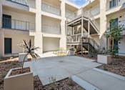 Thumbnail 14 of 38 - Outdoor courtyard with stairway and planter boxes at Altitude Apartments, California