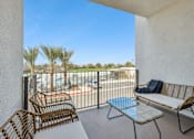 Thumbnail 34 of 38 - Balcony with seating overlooking pool and greenery at Altitude Apartments, California, 92553