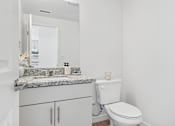 Thumbnail 28 of 38 - Bathroom with granite vanity and white cabinetry at Altitude Apartments, Moreno Valley, CA