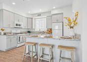 Thumbnail 26 of 38 - Bright kitchen with breakfast bar and stools at Altitude Apartments, Moreno Valley, 92553