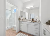 Thumbnail 31 of 38 - Spacious bathroom with dual vanity and walk-in shower at Altitude Apartments, Moreno Valley, California