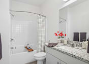 Thumbnail 33 of 38 - Modern bathroom with bathtub and granite countertop at Altitude Apartments, California, 92553