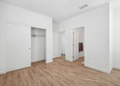 Thumbnail 32 of 38 - Bedroom with walk-in closet and hardwood flooring at Altitude Apartments, Moreno Valley, CA 92553