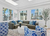 Thumbnail 4 of 38 - Community lounge with curved seating and blue accent chairs at Altitude Apartments, Moreno Valley, CA