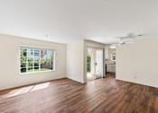 Thumbnail 15 of 26 - Open concept Cielo apartment with plank flooring, large windows, sliding doors leading to private patio, dining area and kitchen.