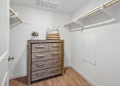Thumbnail 20 of 38 - Walk-in closet with dresser and overhead shelving at Altitude Apartments, Moreno Valley, California