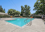 Thumbnail 6 of 31 - Luxurious swimming pool at Bent Tree surrounded by chaise lounges and dining tables for the ultimate poolside experience.