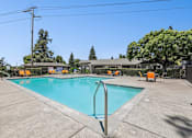 Thumbnail 5 of 31 - Luxurious swimming pool at Bent Tree surrounded by chaise lounges and dining tables for the ultimate poolside experience.