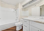 Thumbnail 25 of 26 - Bathroom inside Cielo apartment home with plank flooring, shaker cabinets, and quartz countertops. Spacious shower/tub and plenty of storage