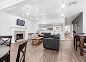 Thumbnail 6 of 37 - Community clubhouse at California Place Apartments with wood flooring, high ceilings, and cozy seating area next to fireplace
