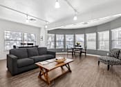 Thumbnail 5 of 37 - Community clubhouse at California Place Apartments with wood flooring, high ceilings, and cozy seating area next to fireplace