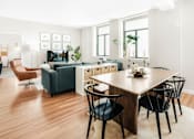 Thumbnail 5 of 17 - A modern living room with a wooden floor and furniture.