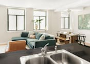 Thumbnail 3 of 17 - A modern kitchen with a green couch and a wooden table.