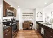 Thumbnail 11 of 12 - a kitchen with dark wood cabinets and stainless steel appliances