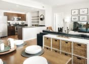 Thumbnail 7 of 12 - a living and dining area with a table and chairs and a kitchen in the background