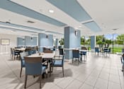 Thumbnail 26 of 37 - A large room with tables and chairs and a blue ceiling at Hampton Apartments, Clearwater 33759