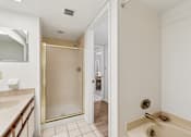Thumbnail 35 of 37 - A bathroom with a walk-in shower and a toilet at Hampton Apartments, Clearwater