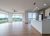 Thumbnail 16 of 28 - A spacious kitchen and living room with a view of the outdoors.