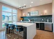 Thumbnail 26 of 28 - A modern kitchen with a bar area and a view of the city.