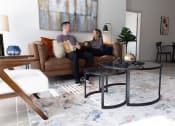 Thumbnail 31 of 33 - a man and woman sitting on a couch in a living room at The Residences at Tesson Ridge, Saint Louis, Missouri
