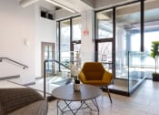 Thumbnail 5 of 33 - a living room with a yellow chair and a table at The Residences at Tesson Ridge, Saint Louis